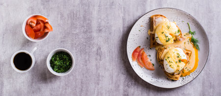 Homemade breakfast with waffles, bacon and eggs benedict on a plate. top view. web bannerの写真素材