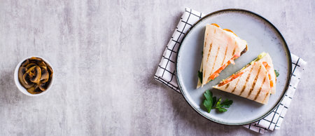 Grilled flatbread stuffed with avocado, mushrooms, tomatoes and parsley on a plate top view web bannerの写真素材