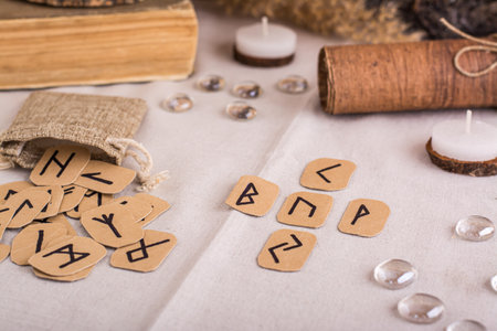 Divination by a cross on homemade Scandinavian runes on the tableの写真素材