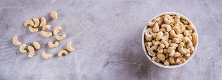 Dried cashew nuts in a bowl on the table for a vegetarian diet top view web bannerの写真素材