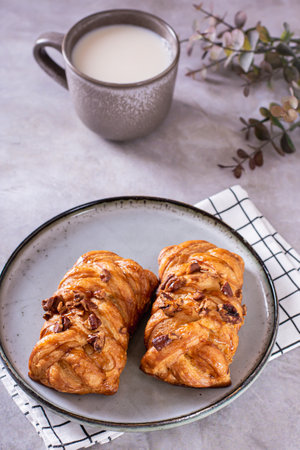 Swedish fika time with fresh cinnamon buns and a cup of latte on the table vertical viewの写真素材