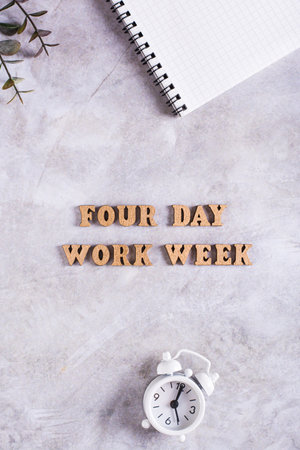 Four day work week concept with wooden letters on desk top and vertical viewの写真素材