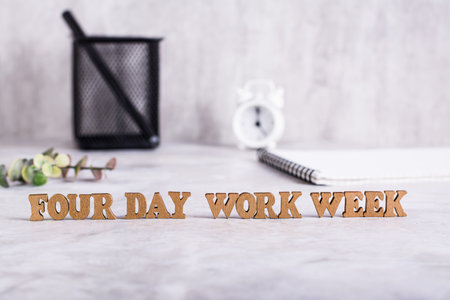 Four day work week word from wooden letters on desktop concept