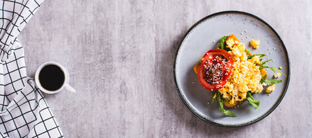 Bruschetta with scrambled egg, arugula, tomato and sesame on a plate top view web bannerの写真素材