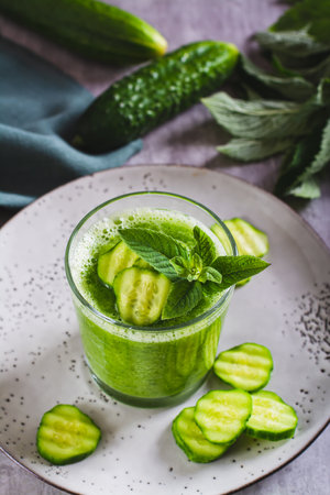Diet cucumber and mint smoothie in a glass for breakfast vertical viewの写真素材