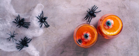 Halloween fruit blood cocktail with eyes and orange in glasses top view web bannerの写真素材