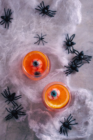 Halloween fruit blood cocktail with eyes and orange in glasses top and vertical viewの写真素材