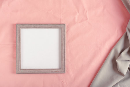 Blank photo frame template on pink cotton fabric top viewの写真素材