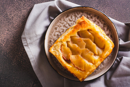 Close up of upside down puff pastry apple tart on a breakfast plate top viewの写真素材