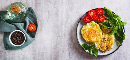 Baked cabbage steaks, fresh tomatoes and basil on a plate top view web bannerの写真素材