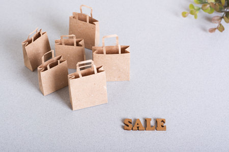Green friday sale paper craft shopping bags and leaves on table
