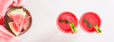 Watermelon lemonade with watermelon pieces in glasses on pink background top view web bannerの写真素材