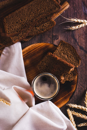 A glass of cold kvass and rye bread for fermentation on the table top and vertical viewの写真素材