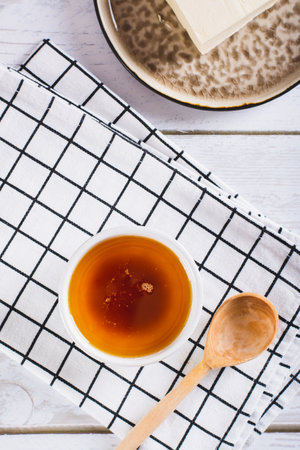 Delicious melted brown butter sauce in a bowl on the table top and vertical viewの写真素材