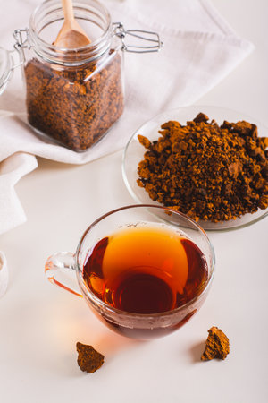 Healing tea from wild birch chaga mushroom in a cup on the table vertical viewの写真素材