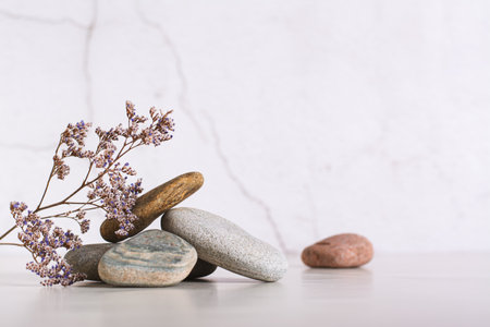 Beautiful composition of smooth sea stones and dried flowers on the tableの写真素材