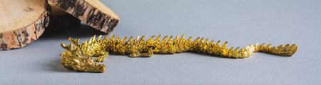 Golden metal dragon and wood slices on a gray background decor for Chinese New Year web bannerの写真素材
