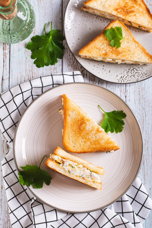 Bacon, egg and herb salad in a trendy chopped grilled sandwich on a plate top and vertical viewの写真素材