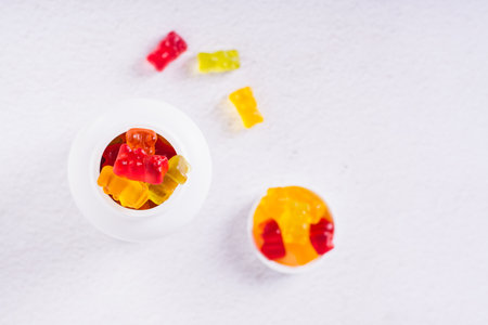 Close up of the bottle with gummy vitamin supplements in the shape of bears on the table top viewの写真素材