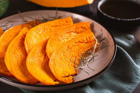 Close-up of sweet baked pumpkin with rosemary on a plateの写真素材