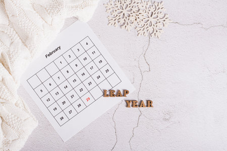 Leap year concept, calendar, sweater and snowflakes on a light background, top viewの写真素材
