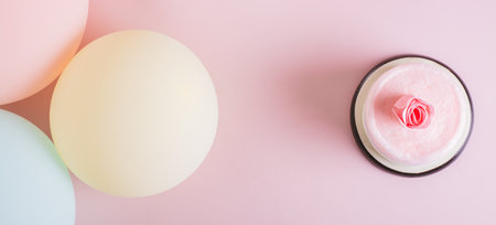 Cotton candy cake, flowers, candles and balloons for party on table top view web banner