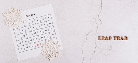 Leap year concept, calendar, snowflakes and text on light top view web bannerの写真素材