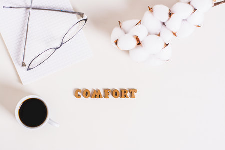 Concept comfort word, cup of coffee, notepad and glasses on a light background top viewの写真素材