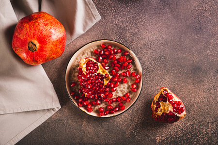 Pieces and seeds of ripe fresh pomegranate on a plate on the table top viewの写真素材