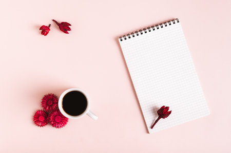 Cup of coffee, dried flowers and open notebook on pink background top view