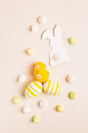 White decorative bunnies, Easter eggs and meringues on a pink background top and vertical view