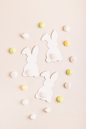 Happy Easter white bunnies, Easter eggs and mini meringues on pink background top and vertical view