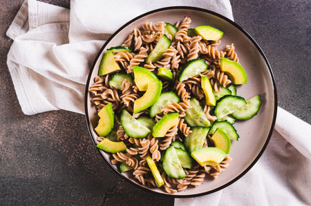 Close up of delicious salad of buckwheat pasta, cucumber and avocado on a plate top viewの写真素材