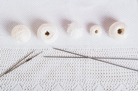 Background knitting balls, hooks and knitting needles on knitted texture top view