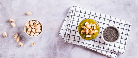 Chia seeds with yogurt, pistachio spread and cashew nuts in a glass top view web bannerの写真素材