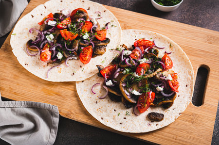 Tortilla with mushrooms, tomatoes, ricotta and onions on a board