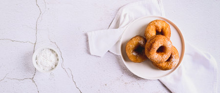 Sweet sugar donuts on a white plate on the table top view web bannerの写真素材