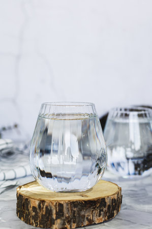 Clean organic water in glasses on table against background in shadows vertical viewの写真素材