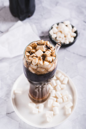 Refreshing fluffy cake with marshmallow in a glass on the table vertical view