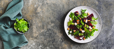 Beetroot salad with cheese, nuts and herbs on a plate on the table top view web bannerの写真素材
