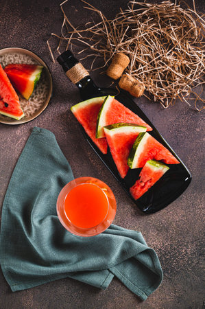 Homemade organic watermelon wine in a glass and watermelon top and vertical viewの写真素材