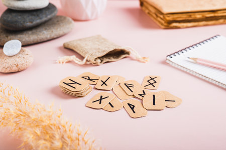 Scandinavian runes, notebook and pencil for writing on pink background