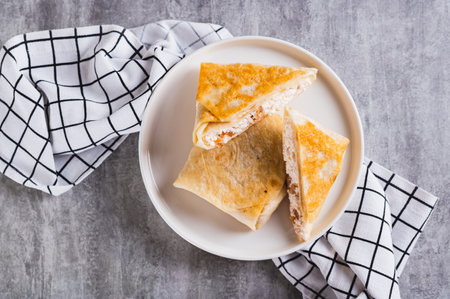 Close up of envelopes with cottage cheese and apple in pita bread on a plate top viewの写真素材