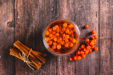 Close up of tea with rowan berries in glasses and cinnamon on the table top viewの写真素材