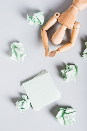 Burnt out man among crumpled note papers on desk top and vertical view