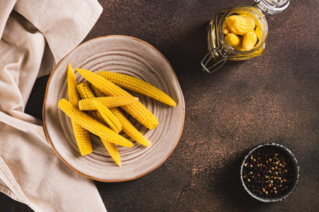 Mini corn cobs on a plate on a table top viewの写真素材