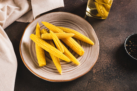 Portion of corn on the cob on a plate and in a jar on a tableの写真素材