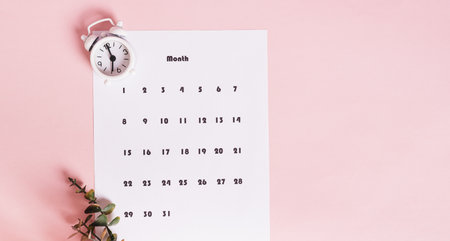 Monthly calendar for planning tasks and alarm clock on pink top view web bannerの写真素材