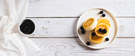 Homemade cottage cheese pancakes and blueberries on a plate on the table top view web bannerの写真素材