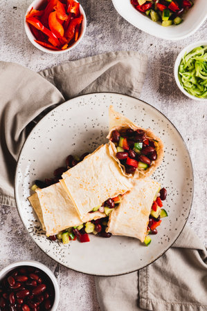 Vegetarian salsa rolls in tortilla on plate on table top and vertical viewの写真素材
